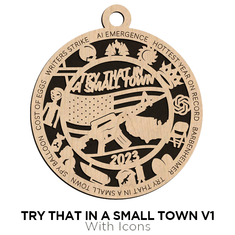 Intricately designed wooden ornament with text "try that in a small town v1 with icons" and various symbols representing rural life and activities, dated 2023, from Brothers DooDads.