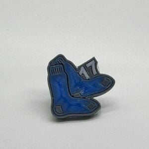 Pair of blue ice skates enamel pin on a white background.